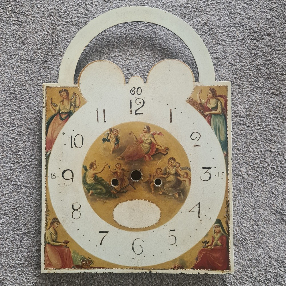 A Regency mahogany longcase clock featuring a swan-neck pediment, a painted dial with a moonphase complication, and a Gothic arch door with flame mahogany veneers. View IX