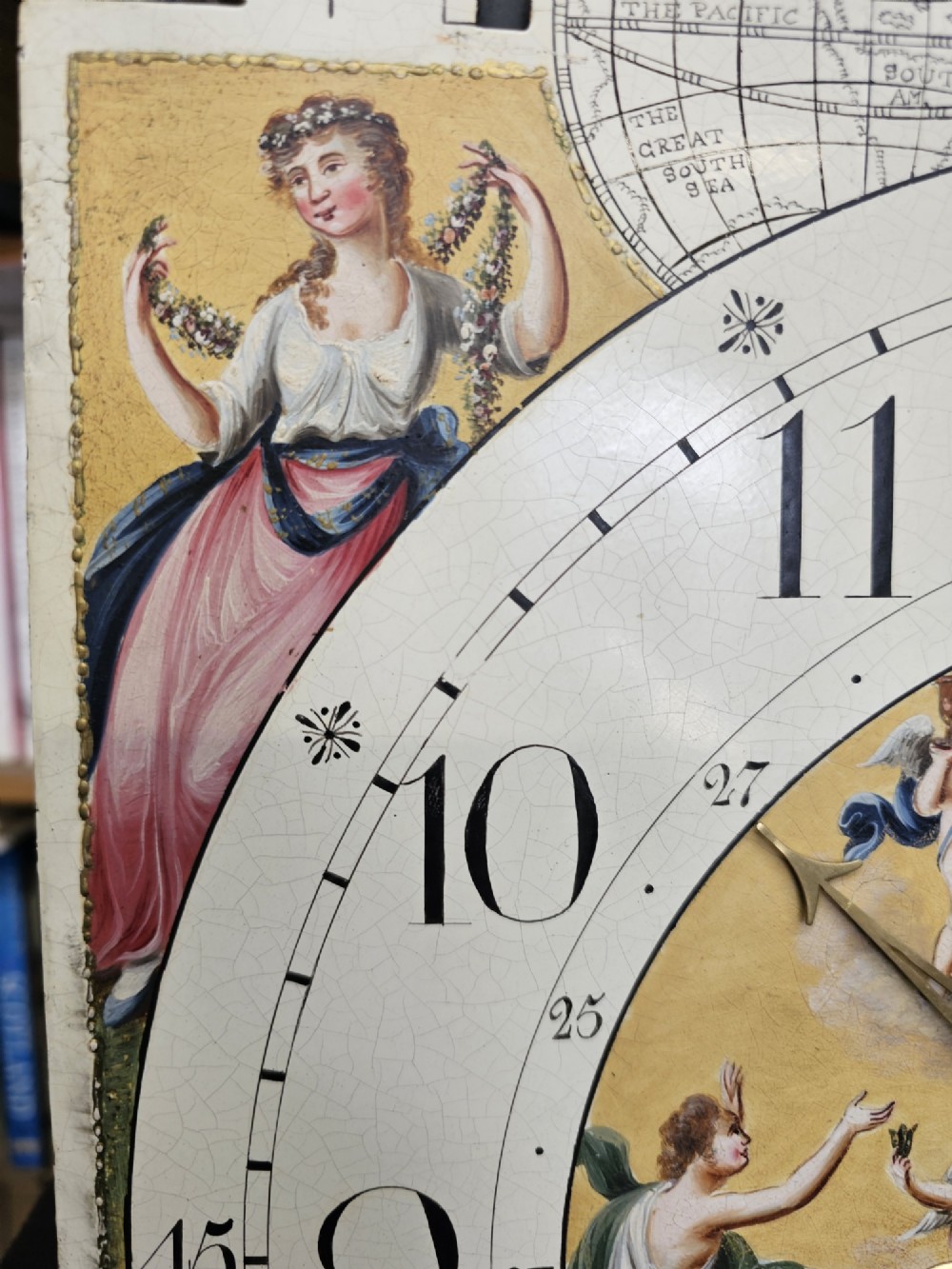 A Regency mahogany longcase clock featuring a swan-neck pediment, a painted dial with a moonphase complication, and a Gothic arch door with flame mahogany veneers. View X