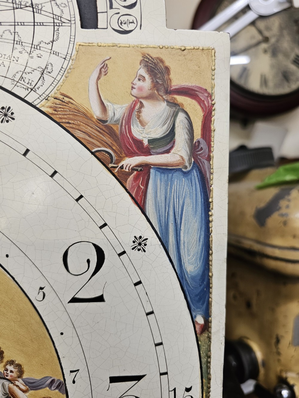 A Regency mahogany longcase clock featuring a swan-neck pediment, a painted dial with a moonphase complication, and a Gothic arch door with flame mahogany veneers. View XI