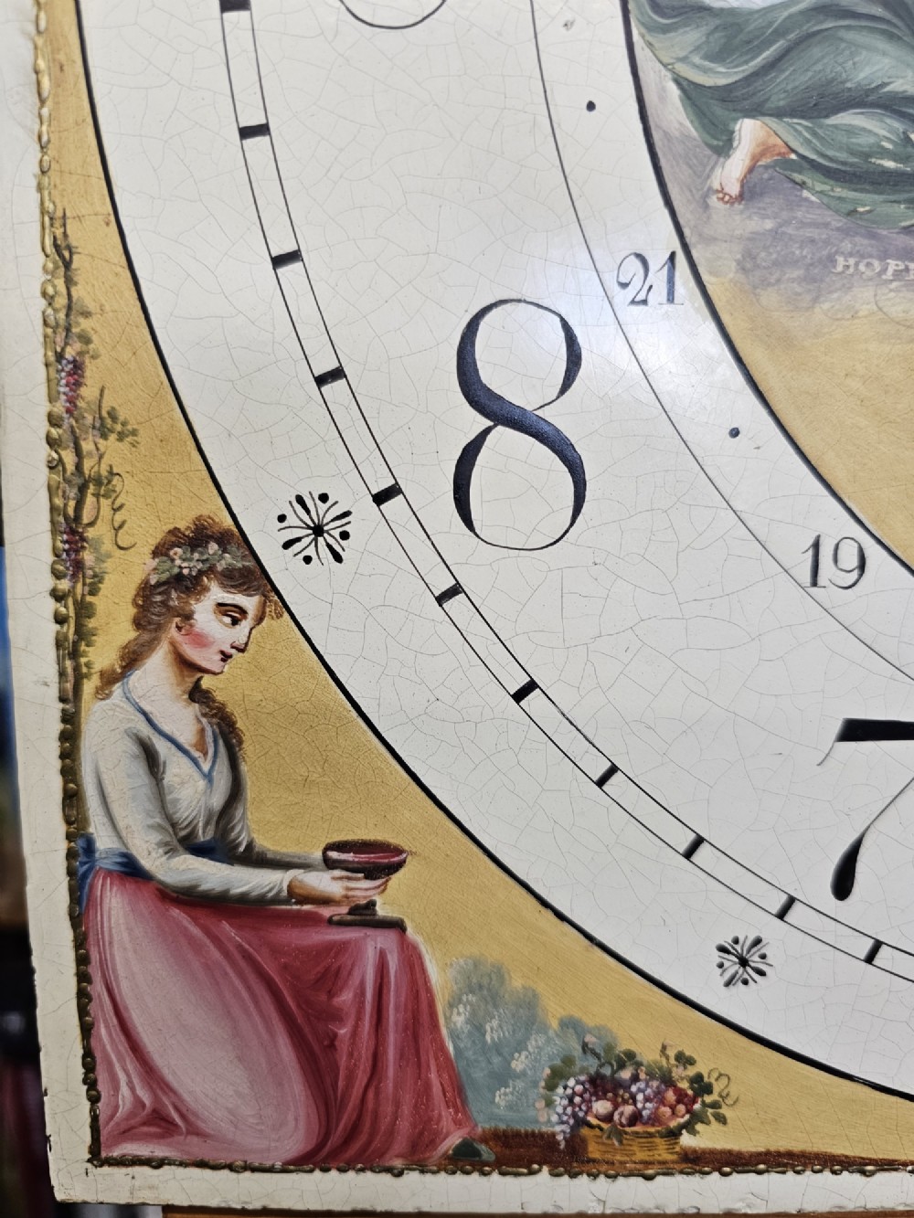 A Regency mahogany longcase clock featuring a swan-neck pediment, a painted dial with a moonphase complication, and a Gothic arch door with flame mahogany veneers. View XIII