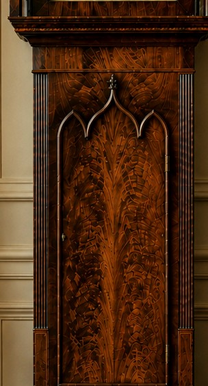 A Regency mahogany longcase clock featuring a swan-neck pediment, a painted dial with a moonphase complication, and a Gothic arch door with flame mahogany veneers. View XIV