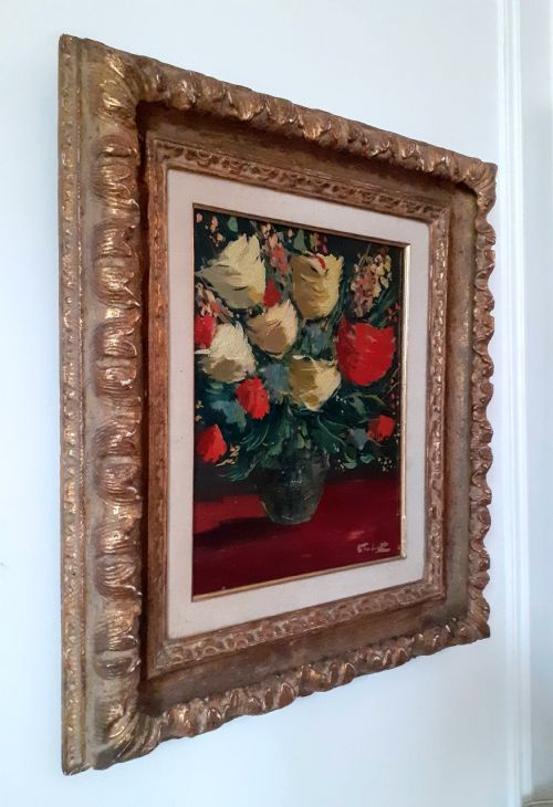 fig 4. A framed oil painting on canvas depicting a bouquet of yellow and red flowers in a glass vase set on a dark red table surface.
