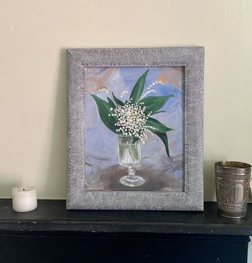fig 1. A mid-century still life oil painting on canvas depicting white lily of the valley flowers in a clear glass vase against a light blue textured background.
