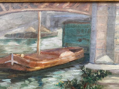 fig 2. An impressionist oil painting depicting a wooden boat moored along the River Seine under a stone bridge, presented in a carved gilded frame.