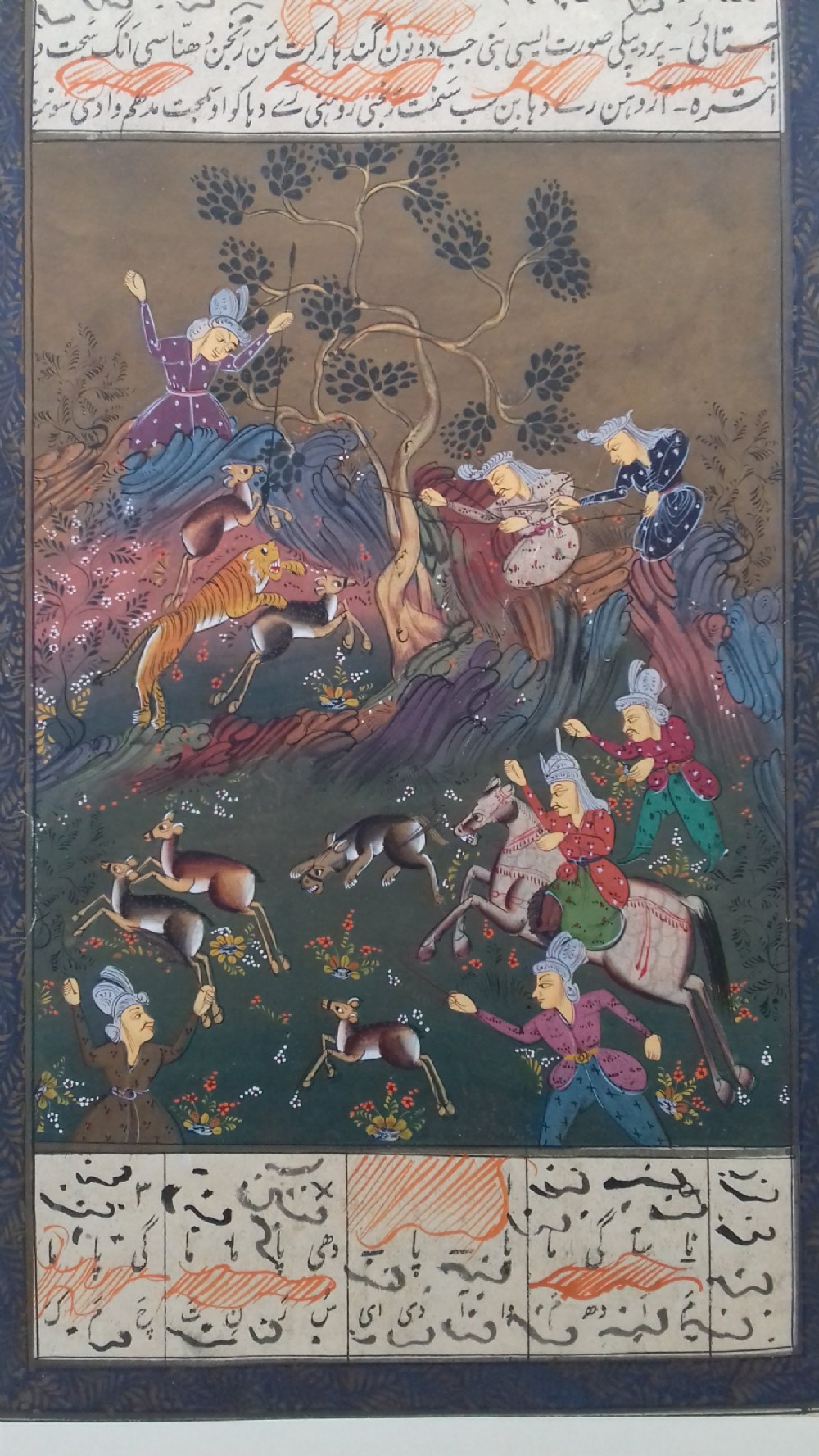 An antique Persian miniature painting in gouache depicting figures on horseback and foot hunting wildlife, bordered by calligraphic panels. View II