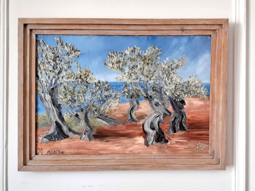 An oil painting on canvas depicting twisted olive trees with thick impasto foliage against a blue sea and terracotta ground, signed M Agostini in the lower left corner. View V