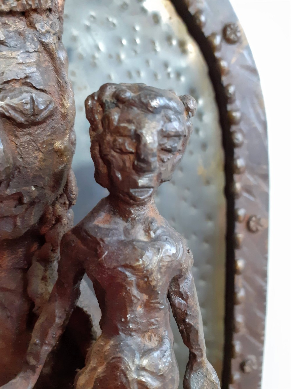 A hand-wrought metal sculpture depicting a crowned Madonna holding the Christ Child within an arched backdrop. View II