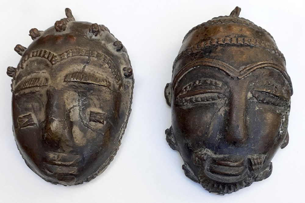 A pair of antique Ashanti African bronze miniature mask pendants, in lost wax technique, Ghana Africa