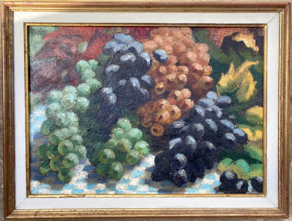 A 1930s Art Deco oil painting on canvas depicting clusters of green, black, and amber grapes resting on a blue and white chequered tablecloth. View III