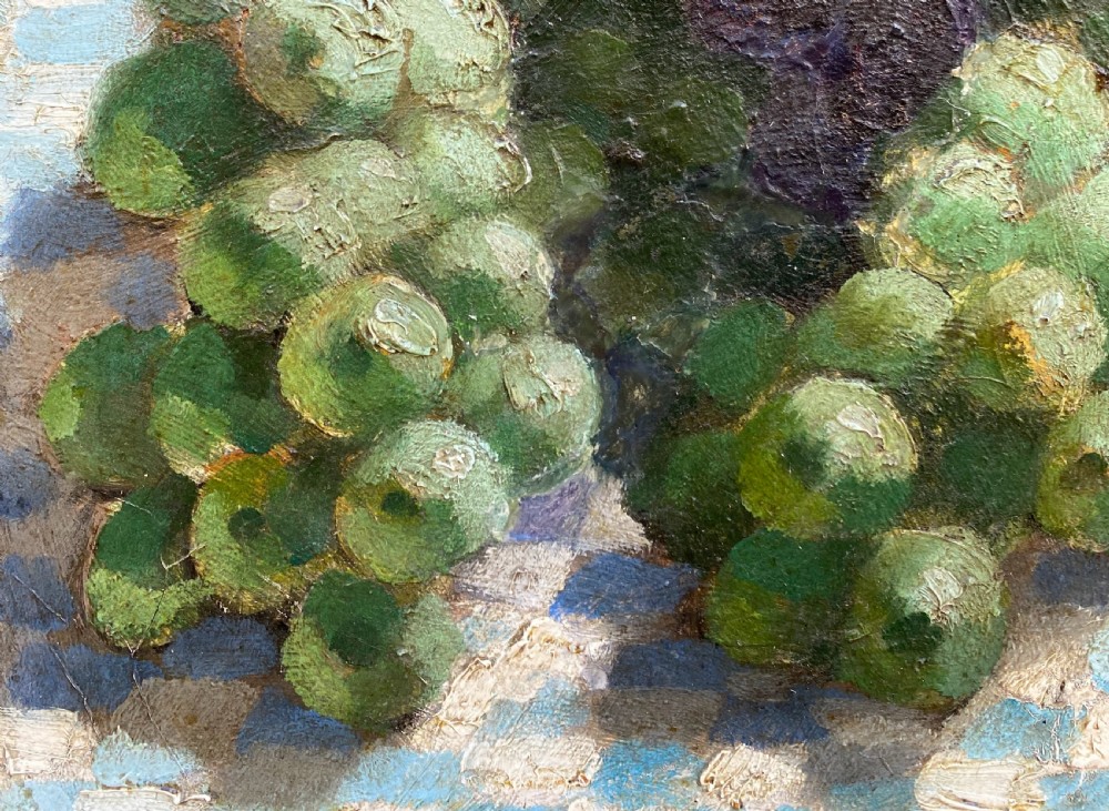 A 1930s Art Deco oil painting on canvas depicting clusters of green, black, and amber grapes resting on a blue and white chequered tablecloth. View IV