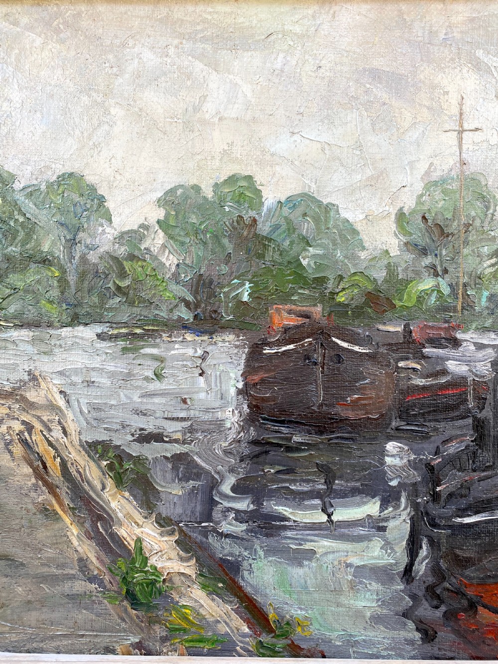 An oil on canvas painting featuring dark wooden barges docked along a riverbank with trees in the background. View IV