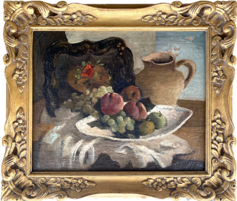 A framed 1920s French modernist oil painting depicting a ceramic pitcher, peaches, and grapes on a table beside a window in a gilded frame.