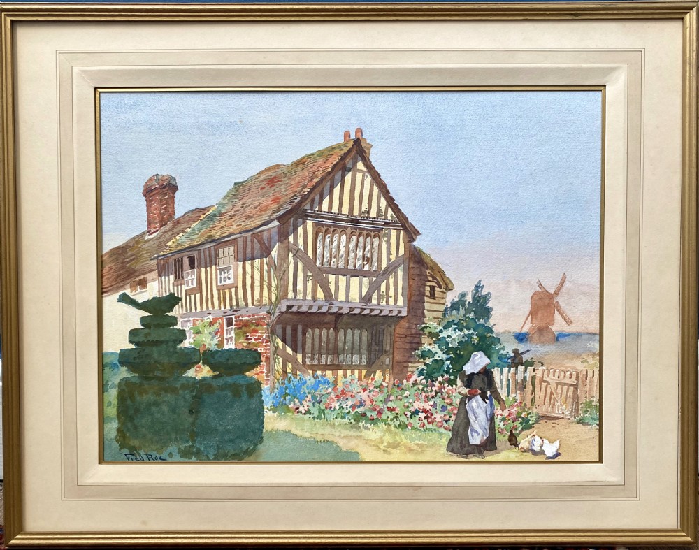 An Edwardian watercolour painting depicting a half-timbered coastal cottage with shaped topiary, a figure feeding chickens in a flower garden, and a distant windmill. View II