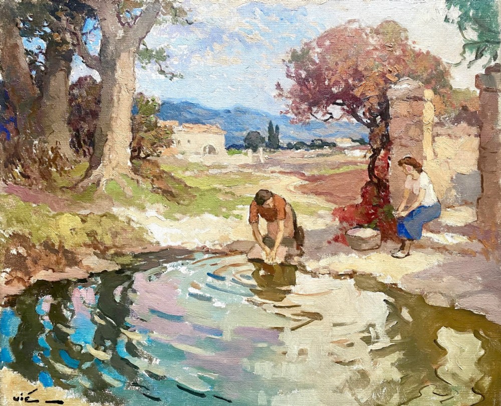 A mid-century French oil painting depicting two washerwomen working beside a reflecting stream in a sunlit Provencal countryside landscape.