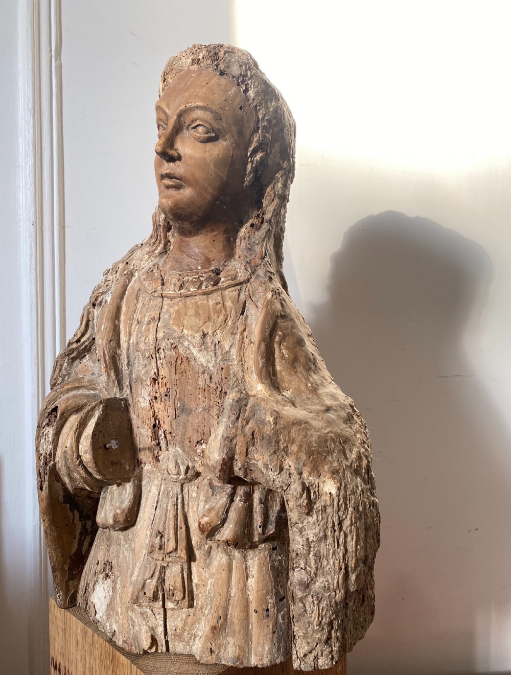 A weathered 16th-century French Renaissance carved timber sculpture fragment depicting a religious figure with detailed drapery and long hair. View III
