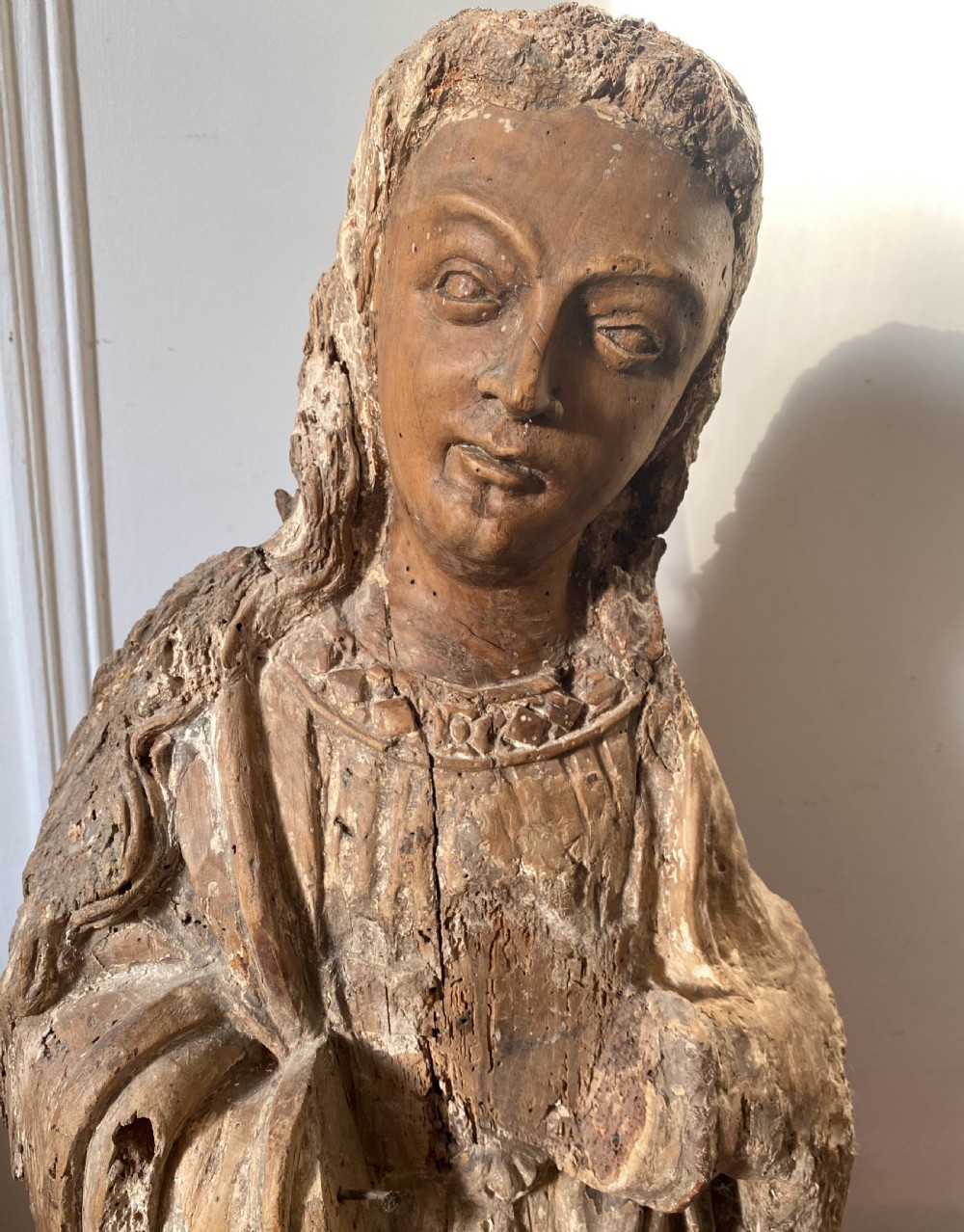 A weathered 16th-century French Renaissance carved timber sculpture fragment depicting a religious figure with detailed drapery and long hair. View IV