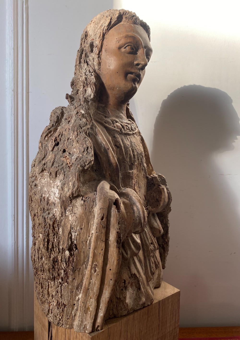 A weathered 16th-century French Renaissance carved timber sculpture fragment depicting a religious figure with detailed drapery and long hair. View VIII