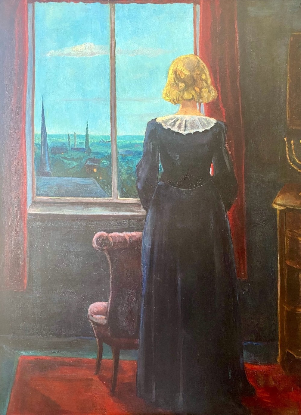 An oil on board painting from 1938 depicting a woman in a dark dress standing by a window framed with red curtains and looking out at a town skyline.
