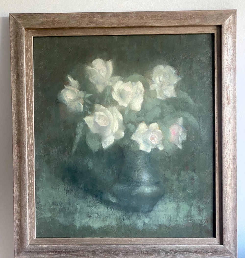 An antique early twentieth-century oil painting on board depicting pale white roses in a dark vase set against a muted green background. View III