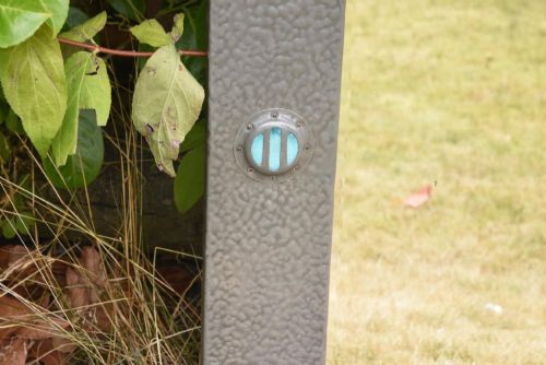 fig 3. A rectangular Arts and Crafts wall mirror featuring a hammered pewter metal frame decorated with corner rivets and two circular turquoise ceramic cabochons on the side borders.