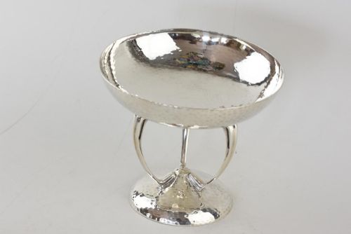 fig 1. A hand-hammered sterling silver tazza dish supported by three curved legs attached to a round raised base.