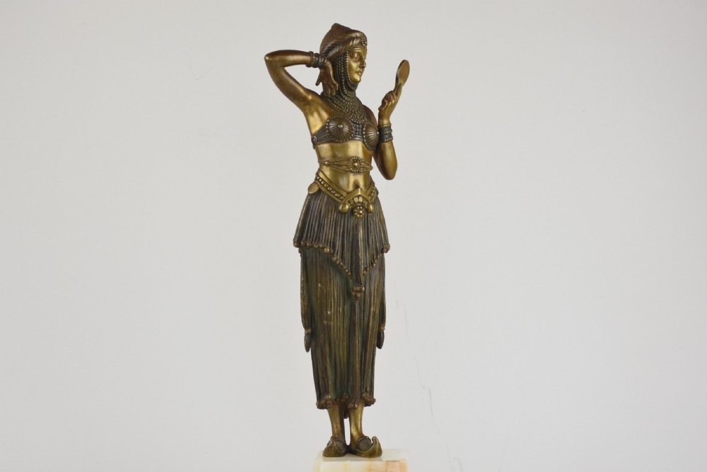 An Art Deco bronze figure depicting a female dancer in theatrical attire holding a small hand mirror, mounted on a square onyx plinth. View IV
