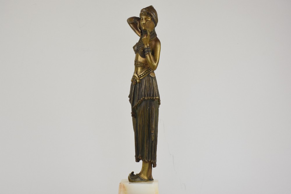 An Art Deco bronze figure depicting a female dancer in theatrical attire holding a small hand mirror, mounted on a square onyx plinth. View V