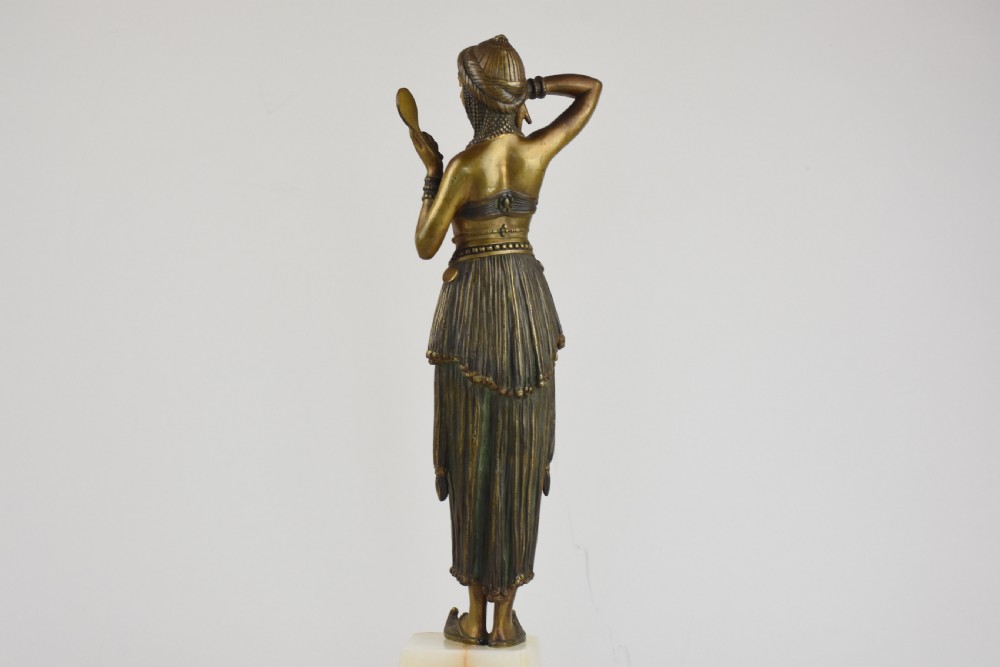 An Art Deco bronze figure depicting a female dancer in theatrical attire holding a small hand mirror, mounted on a square onyx plinth. View VI
