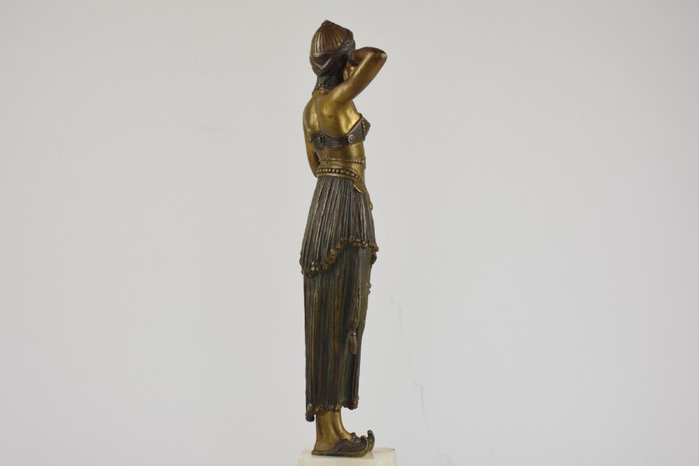 An Art Deco bronze figure depicting a female dancer in theatrical attire holding a small hand mirror, mounted on a square onyx plinth. View VII