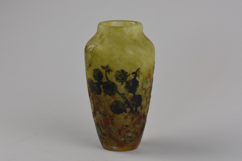 An Art Nouveau mottled yellow and green cameo glass vase decorated with acid-etched and enamelled dark blackberry branches.