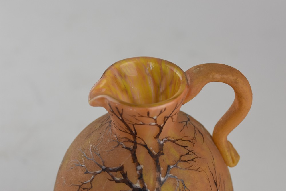 An Art Nouveau Daum Nancy glass jug featuring acid-etched and enamelled winter landscape decoration on an orange gradient background, complete with a spherical stopper. View V