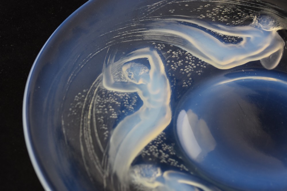 A circular opalescent glass plate featuring press-moulded relief figures of swimming nymphs amidst swirling water motifs. View III