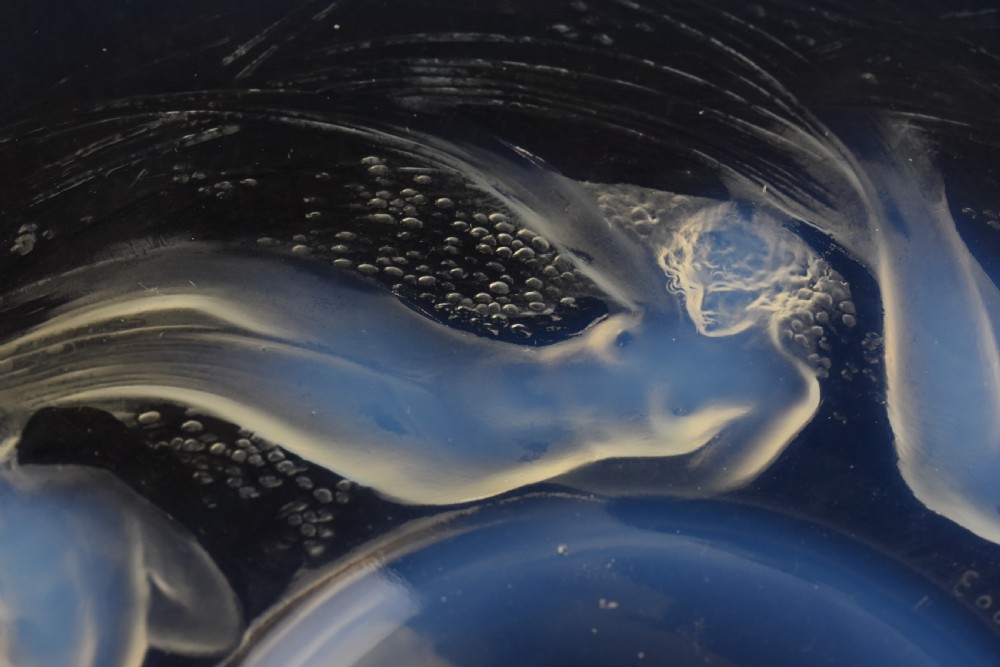A circular opalescent glass plate featuring press-moulded relief figures of swimming nymphs amidst swirling water motifs. View V