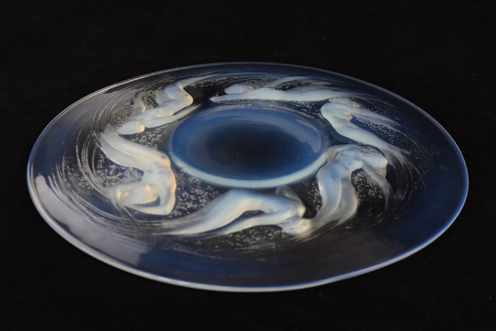 A circular opalescent glass plate featuring press-moulded relief figures of swimming nymphs amidst swirling water motifs. View VII