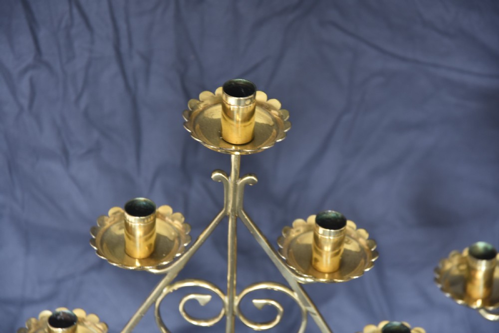 A pair of Arts and Crafts five-light brass candelabra featuring openwork scroll framing, twisted stems, and circular stepped bases. View II