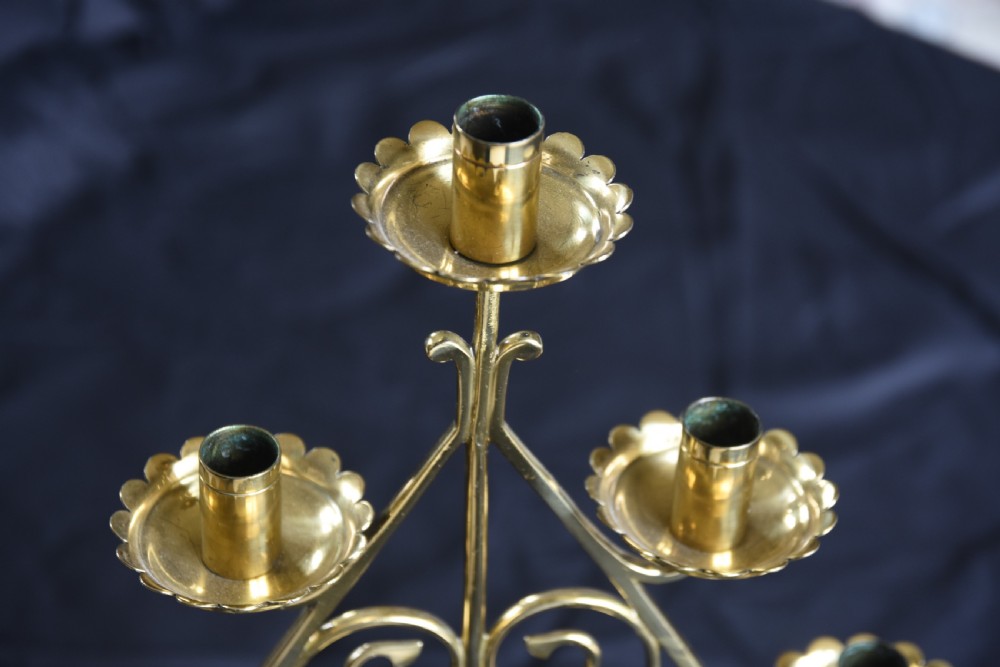 A pair of Arts and Crafts five-light brass candelabra featuring openwork scroll framing, twisted stems, and circular stepped bases. View III