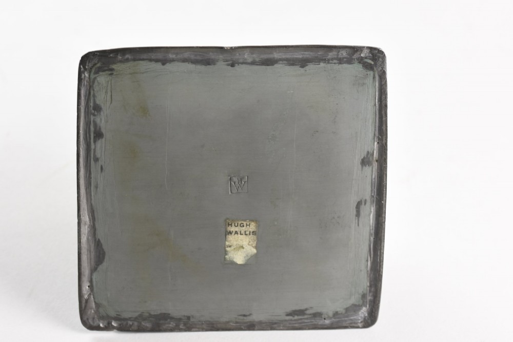 A square tapered hand-hammered pewter inkwell featuring a circular lid and stamped chevron borders around the edges. View IV