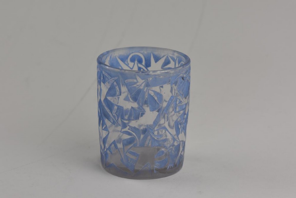 A small cylindrical clear and frosted glass vessel decorated with an embossed ivy motif highlighted with blue stain.