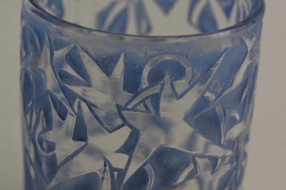 A small cylindrical clear and frosted glass vessel decorated with an embossed ivy motif highlighted with blue stain. View VI