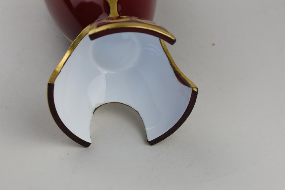 An Art Nouveau deep red glass vase with gilded enamel lotus motifs, featuring a shaped rim and a four-footed base. View IV