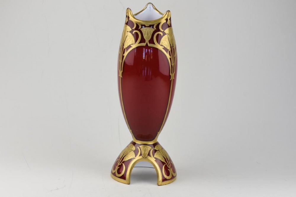 An Art Nouveau deep red glass vase with gilded enamel lotus motifs, featuring a shaped rim and a four-footed base. View VI