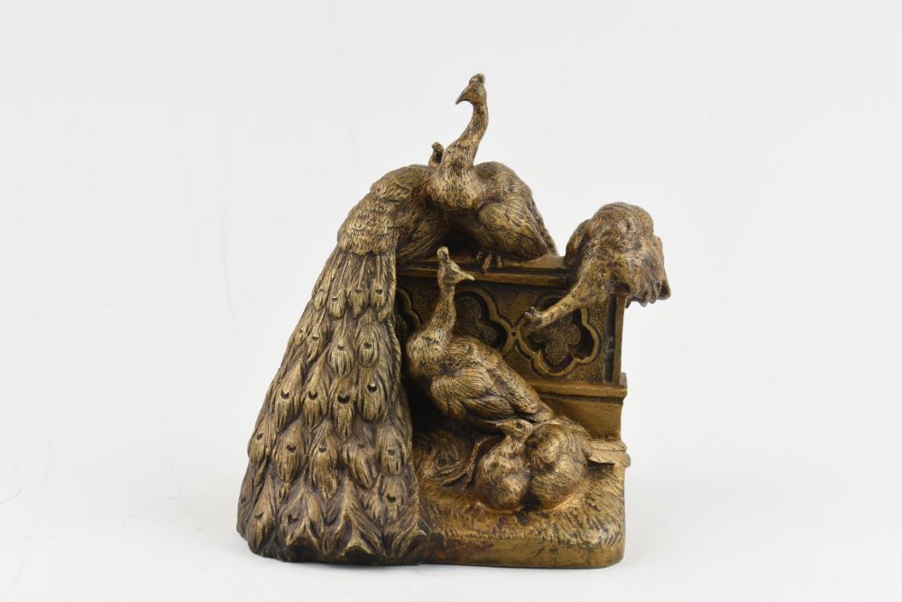 A French Art Nouveau patinated bronze sculpture depicting five peacocks perched around a carved balustrade.