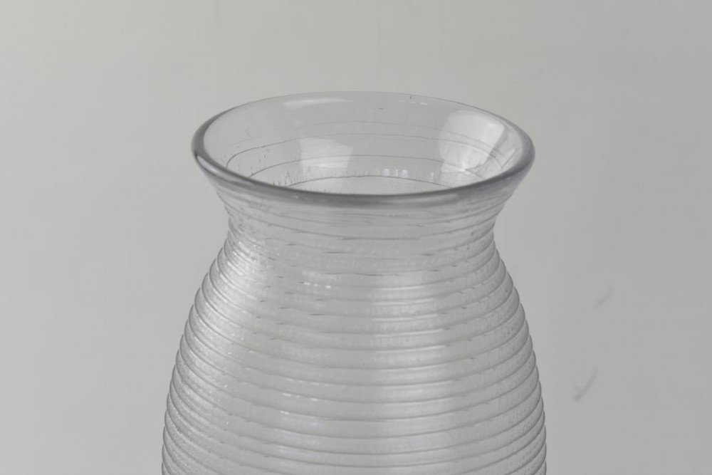 A ribbed grey glass vase with a flared rim resting on an octagonal black base. View II