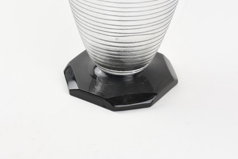 A ribbed grey glass vase with a flared rim resting on an octagonal black base. View III