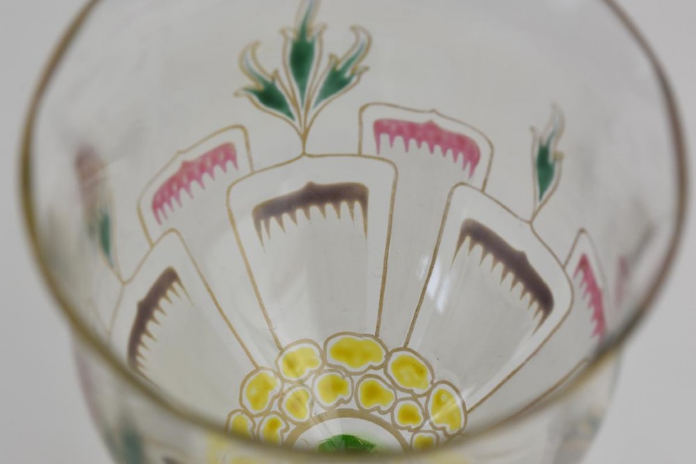 An Art Nouveau wine glass featuring an elongated green stem and a clear bowl decorated with pink and green enamelled floral motifs. View III