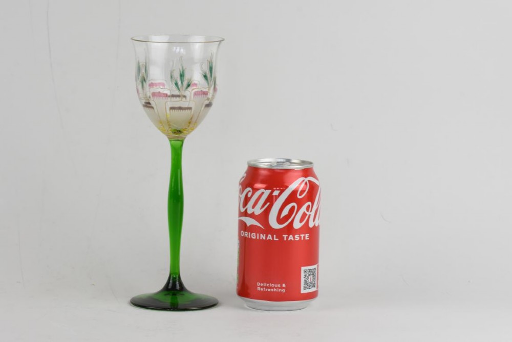 An Art Nouveau wine glass featuring an elongated green stem and a clear bowl decorated with pink and green enamelled floral motifs. View V