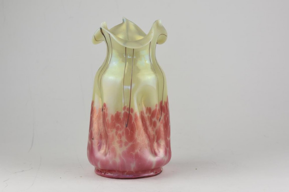 An Art Nouveau iridescent glass vase featuring a pale yellow upper section with dark glass trailing and a speckled pink lower base with a ruffled rim. View III