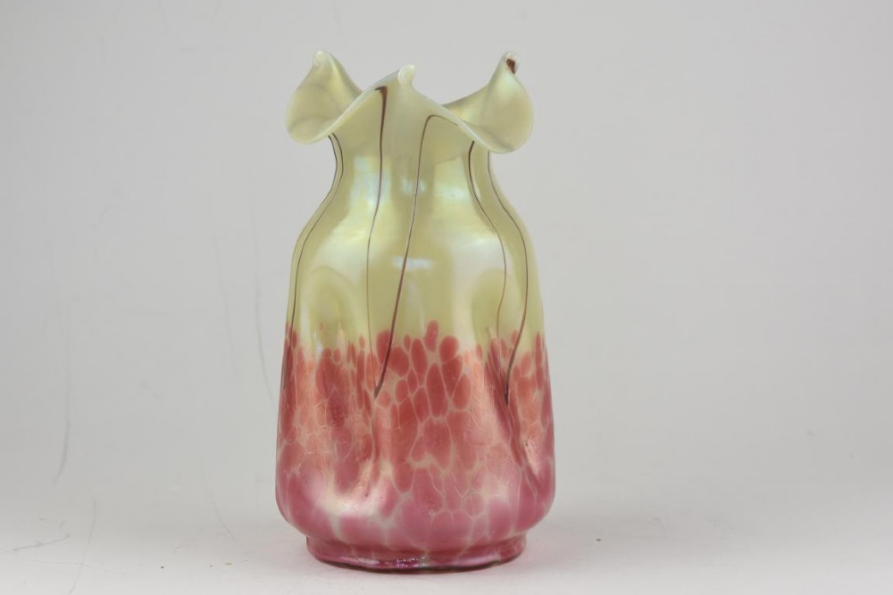 An Art Nouveau iridescent glass vase featuring a pale yellow upper section with dark glass trailing and a speckled pink lower base with a ruffled rim. View IV