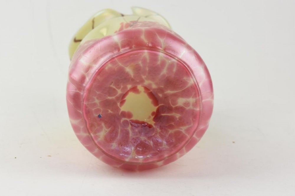An Art Nouveau iridescent glass vase featuring a pale yellow upper section with dark glass trailing and a speckled pink lower base with a ruffled rim. View VI