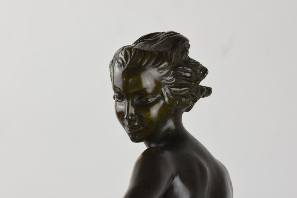 An Art Deco dark patinated bronze figure of a female dancer holding cymbals, balanced on one leg atop a tall green-veined marble base. View V